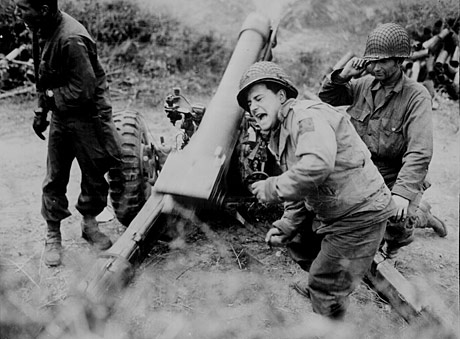 Soldiers fire a mortar in northern France during WWII